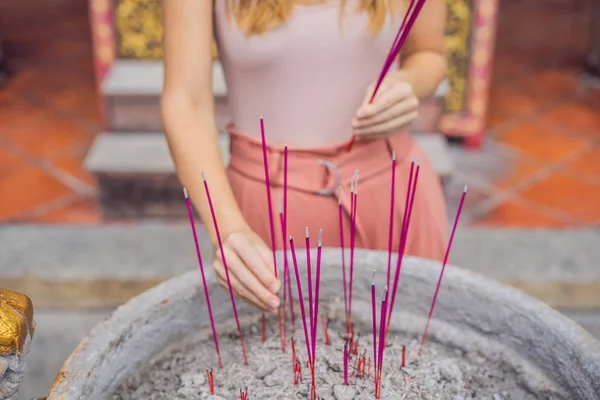 Incense sticks on joss stick pot are burning and smoke use for pay respect to the Buddha, Incense sticks in woman hands and smoke use for pray respect to the Buddha in Buddhism life.