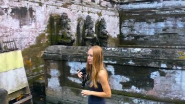 Genç kadın Goa Gajah tapınakta Bali Adası'nda dolaşan çocuk ise antik heykel resim çekme