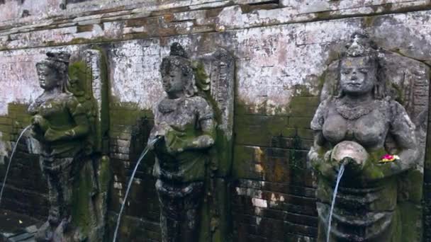 在印度尼西亚巴厘岛岛上的乌布度假村的古印度教寺庙里的古代雕像流出的水 — 图库视频影像
