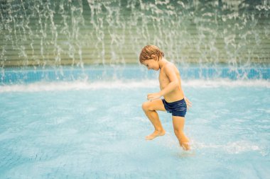 Küçük çocuk yüzme havuzunda eğleniyor.