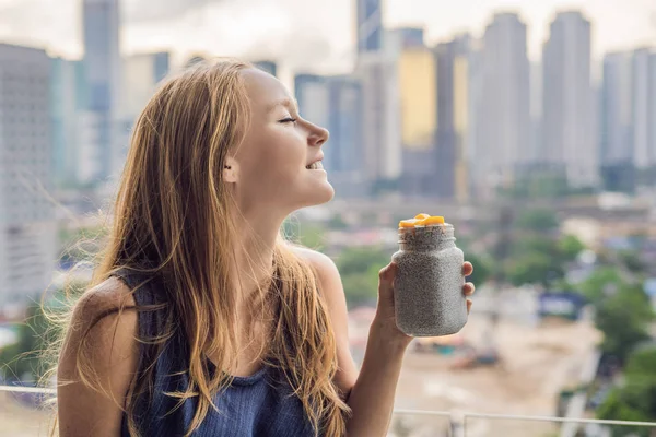 Young Woman Eating Chia Pudding Her Balcony Overlooking Big City — Stock Photo, Image