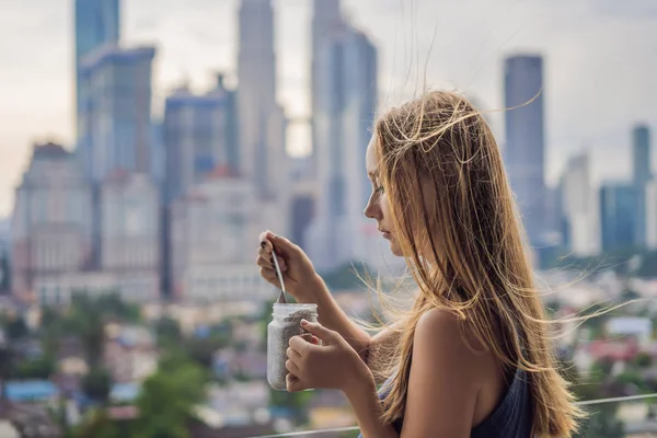 Mujer Joven Comiendo Pudín Chía Balcón Con Vistas Gran Ciudad — Foto de Stock