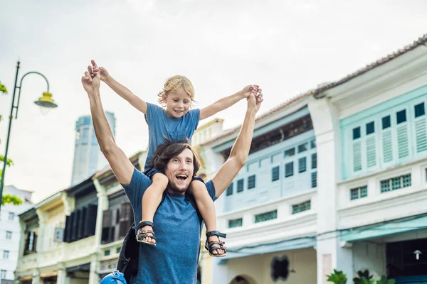 Baba ve oğlu içinde belgili tanımlık geçmiş eski evler eski şehir Georgetown'da, Penang, Malezya.