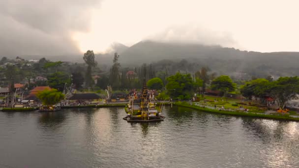 Vue aérienne sur le temple Pura Ulun Danu sur le lac Bratan à Bali, Indonésie. Drone se déplace directement au temple — Video