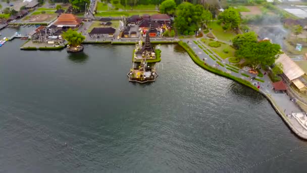 Вид с воздуха на храм Пура Улун Дану на озере Братан в Бали, Индонезия. Дрон движется прямо к храму. — стоковое видео