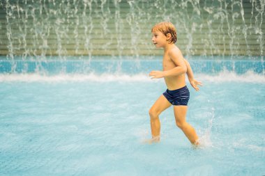Küçük çocuk yüzme havuzunda eğleniyor.