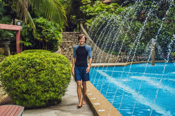 Swimming trainer in clothes for swimming standing near pool
