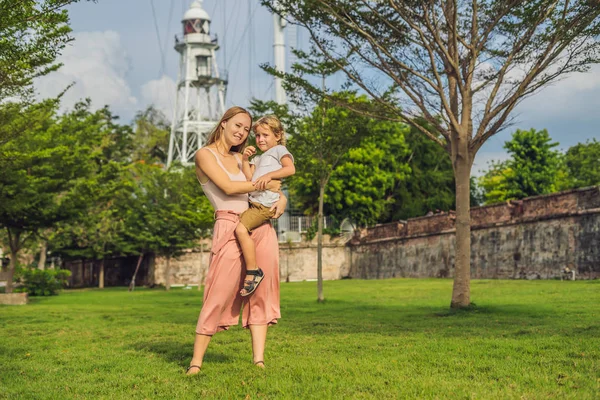 Mom and son on background of Fort Cornwallis in Georgetown, Penang, is a star fort built by the British East India Company in the late 18th century, it is the largest standing fort in Malaysia. Traveling with children concept.