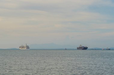 Liner ve kargo gemisi ufukta.