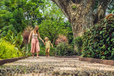 Anne ve oğlu yürümek üstünde A dokulu Arnavut kaldırımı kaplama, refleksoloji. Kaldırımda ayak refleksoloji için çakıl taşları.