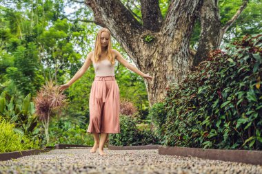 Refleksoloji bir dokulu Arnavut kaldırımı kaldırımda yürüyen kadın. Kaldırımda ayak refleksoloji için çakıl taşları.