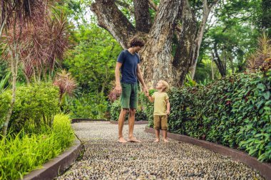 Baba ve oğul yürümek üstünde A dokulu Arnavut kaldırımı kaplama, refleksoloji. Kaldırımda ayak refleksoloji için çakıl taşları.