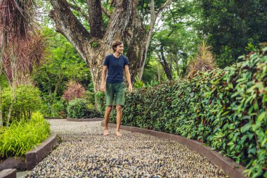 Refleksoloji bir dokulu Arnavut kaldırımı kaldırımda yürüyen adam. Kaldırımda ayak refleksoloji için çakıl taşları.