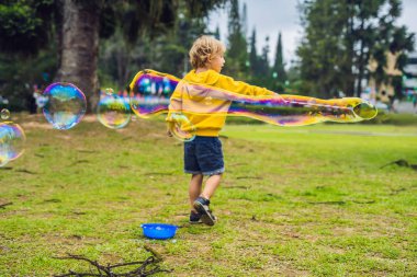 Sevimli küçük çocuk büyük kabarcıklar gündüz açık ile oynuyor