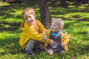 Sonbahar parkta sarı tişörtü iki mutlu kardeşler