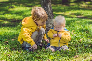 Sonbahar parkta sarı tişörtü iki mutlu kardeşler