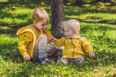 Sonbahar parkta sarı tişörtü iki mutlu kardeşler
