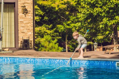 Yürümeye başlayan çocuk havuzunu temizliyor ve topu havuzdan çeker. Havuz temizleyicisi kavramı.