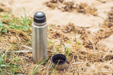 Termos sıcak çay ile zemin sonbahar Plajı'nda yer