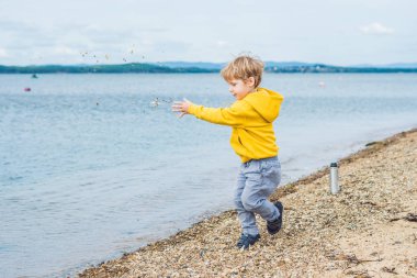 Taş denizde su plajdan gündüz atan genç çocuk
