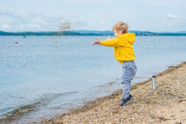 Taş denizde su plajdan gündüz atan genç çocuk