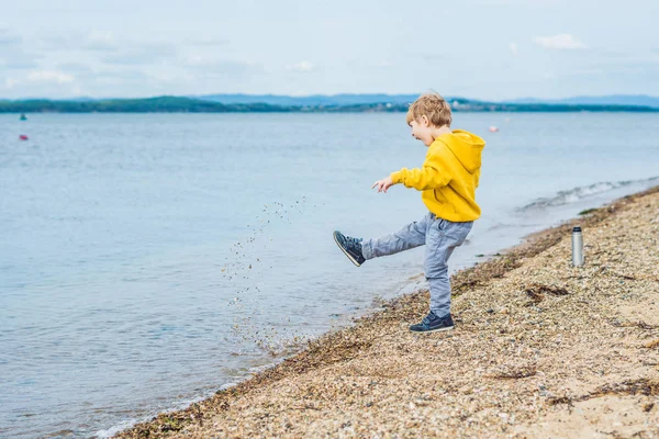 Junge Wirft Tagsüber Steine Vom Strand Ins Meerwasser — Stockfoto
