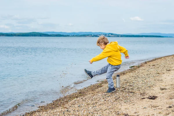 Junge Wirft Tagsüber Steine Vom Strand Ins Meerwasser — Stockfoto