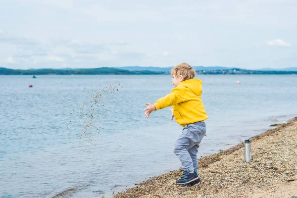 Junge Wirft Tagsüber Steine Vom Strand Ins Meerwasser — Stockfoto