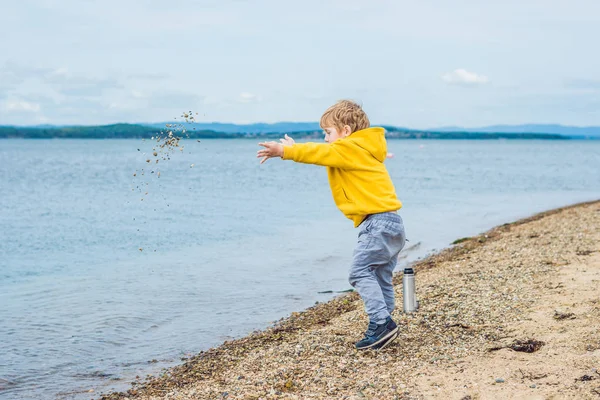 Young Boy Throwing Stones Sea Water Beach Daytime — Stock Photo, Image