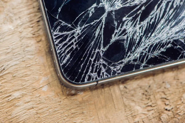 Kırılmış cam üzerinde ahşap bir masa ile Smartphone ekran