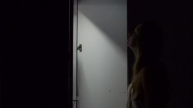 Gece genç kadın bir dolap açar ve üzerinde elbise için seçin