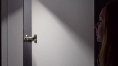 Gece genç kadın bir dolap açar ve üzerinde elbise için seçin