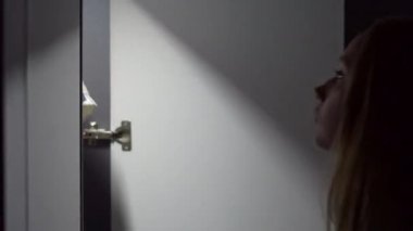 Gece genç kadın bir dolap açar ve üzerinde elbise için seçin