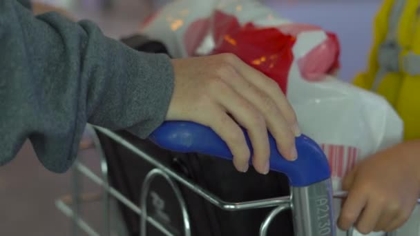 Steadicam schot van een jonge vrouw en haar zoontje wandelen in een luchthaven — Stockvideo