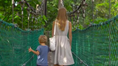 Genç bir kadın ve oğlu asılı asma köprü Kuala Lumpur City Eko Park'ta yürüyüş Steadicam atış