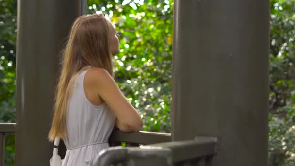 Steadicam shot van een jonge vrouw lopen op de opknoping hangbrug in het Eco Park in de stad van Kuala Lumpur — Stockvideo