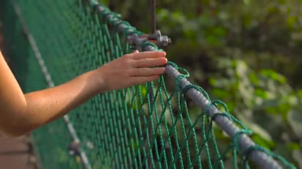 Steadicam tiro de uma jovem caminhando na ponte suspensa no Eco Park, na cidade de Kuala Lumpur — Vídeo de Stock