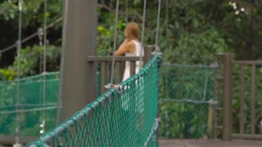 Genç bir kadın ve oğlu asılı asma köprü Kuala Lumpur City Eko Park'ta yürüyüş Steadicam atış