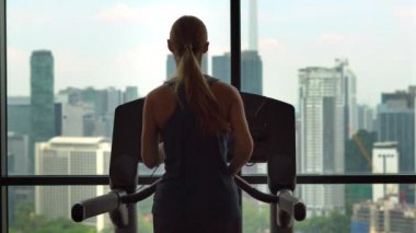 Bir koşu parkuru koca bir şehir manzaralı bir gökdelen eğitim üzerine bir spor salonunda genç kadın