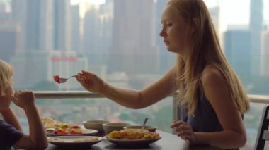 Genç aile bir kahvaltı, Bütün şehir şehir manzaralı bir gökdelen onların balkonda yemek