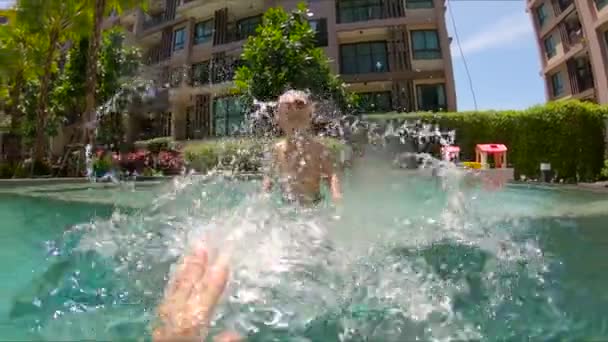 Pai e filho brincando e salpicando em uma piscina em trópicos — Vídeo de Stock