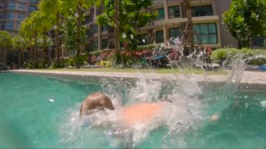 Küçük çocuk havuza atlama kadeh Slowmotion