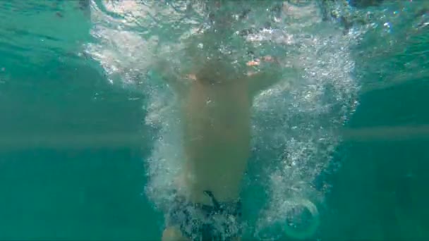 Slowmotion coup de petit garçon plongeant et éclaboussant dans une piscine — Video