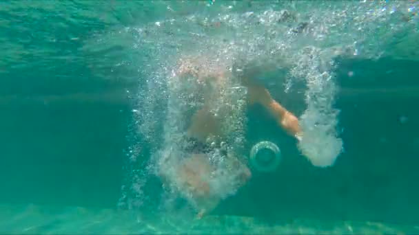 Fotografía en cámara lenta de un niño buceando y chapoteando en una piscina — Vídeo de stock