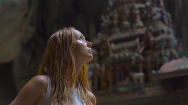 Νεαρή γυναίκα επίσκεψη αρχαία σπήλαια Μπατού Μαλαισία έχοντας ένα ινδουιστικό ναό στο εσωτερικό — Αρχείο Βίντεο