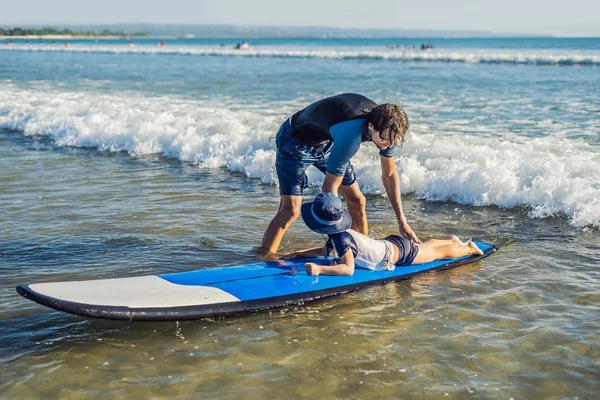 彼の若い息子の休暇や休日の海でサーフィンする方法を教えます 旅行や子供たちのコンセプトとスポーツ — ストック写真