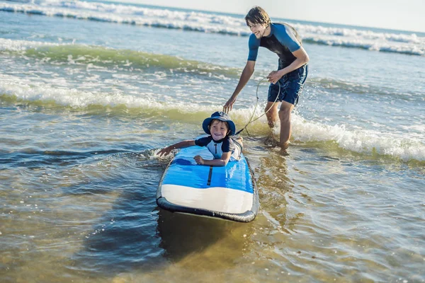 父亲教他的小儿子在假期或度假时如何在海里冲浪 旅游与儿童运动概念 — 图库照片