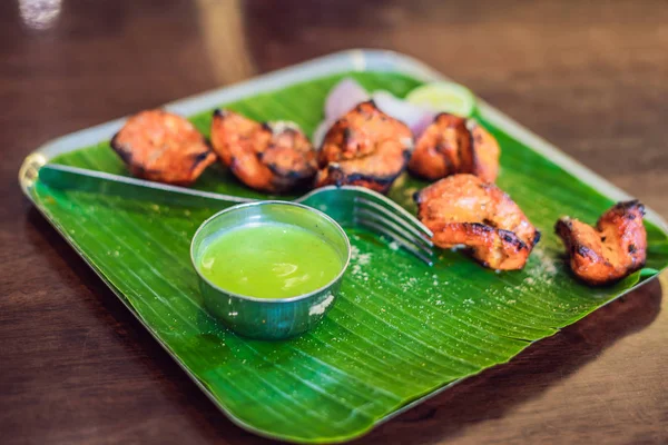 Koyu ahşap arka plan üzerinde çeşitli Hint yemeği. Yemekler ve mezeler Hint Mutfak. Köri, tereyağı tavuk, pirinç, mercimek, paneer, samosa, naan, Hint turşusu, baharatlar. Kase ve Hint yemekleri ile plakalar.