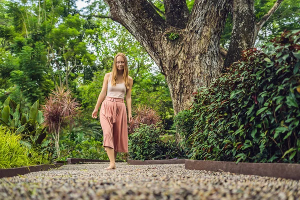 Refleksoloji bir dokulu Arnavut kaldırımı kaldırımda yürüyen kadın. Kaldırımda ayak refleksoloji için çakıl taşları.