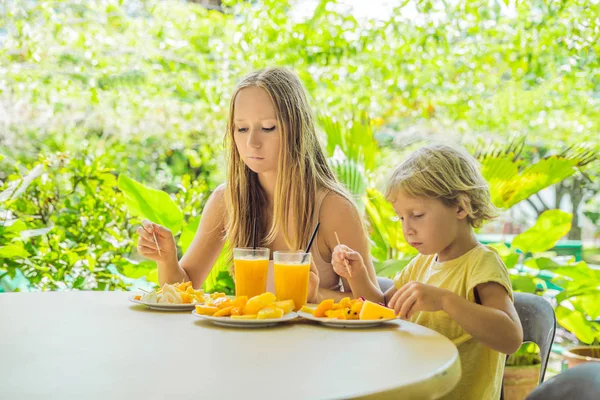 Anne ve oğlu meyve ve meyve suyu bir kafede yemek